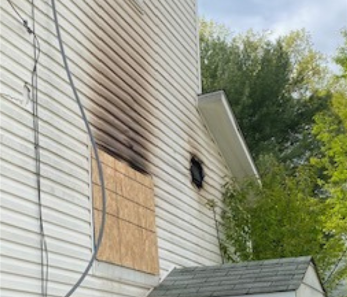 House with fire damage and boarded window